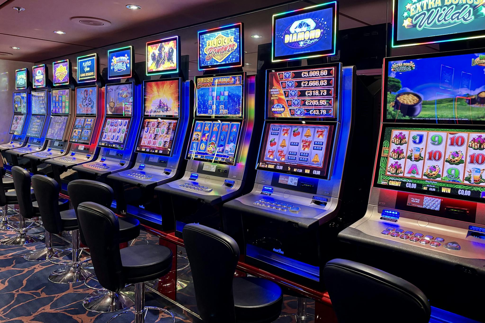 Bright casino slot machines with colorful displays and no people present.
