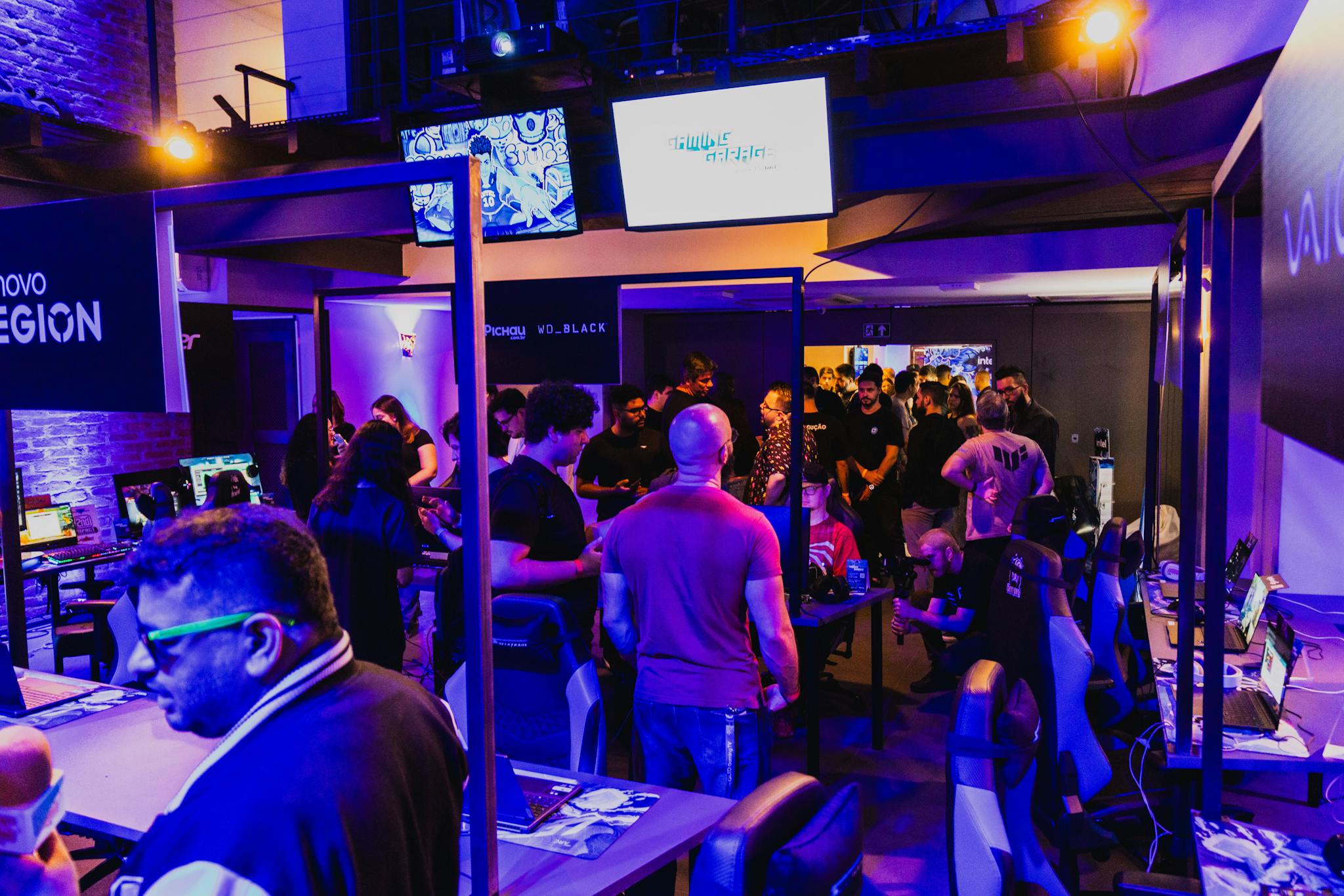 Vibrant arcade room filled with gamers participating in a competitive tournament under violet lighting.